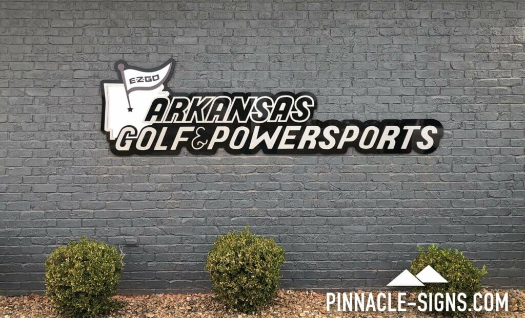 black and white building sign that reads Arkansas Golf & Powersports