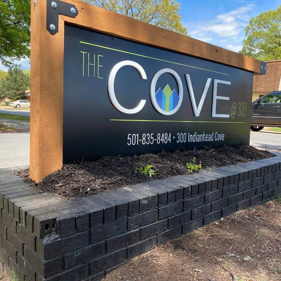 The Cove apartments monument sign with wood frame and black brick base