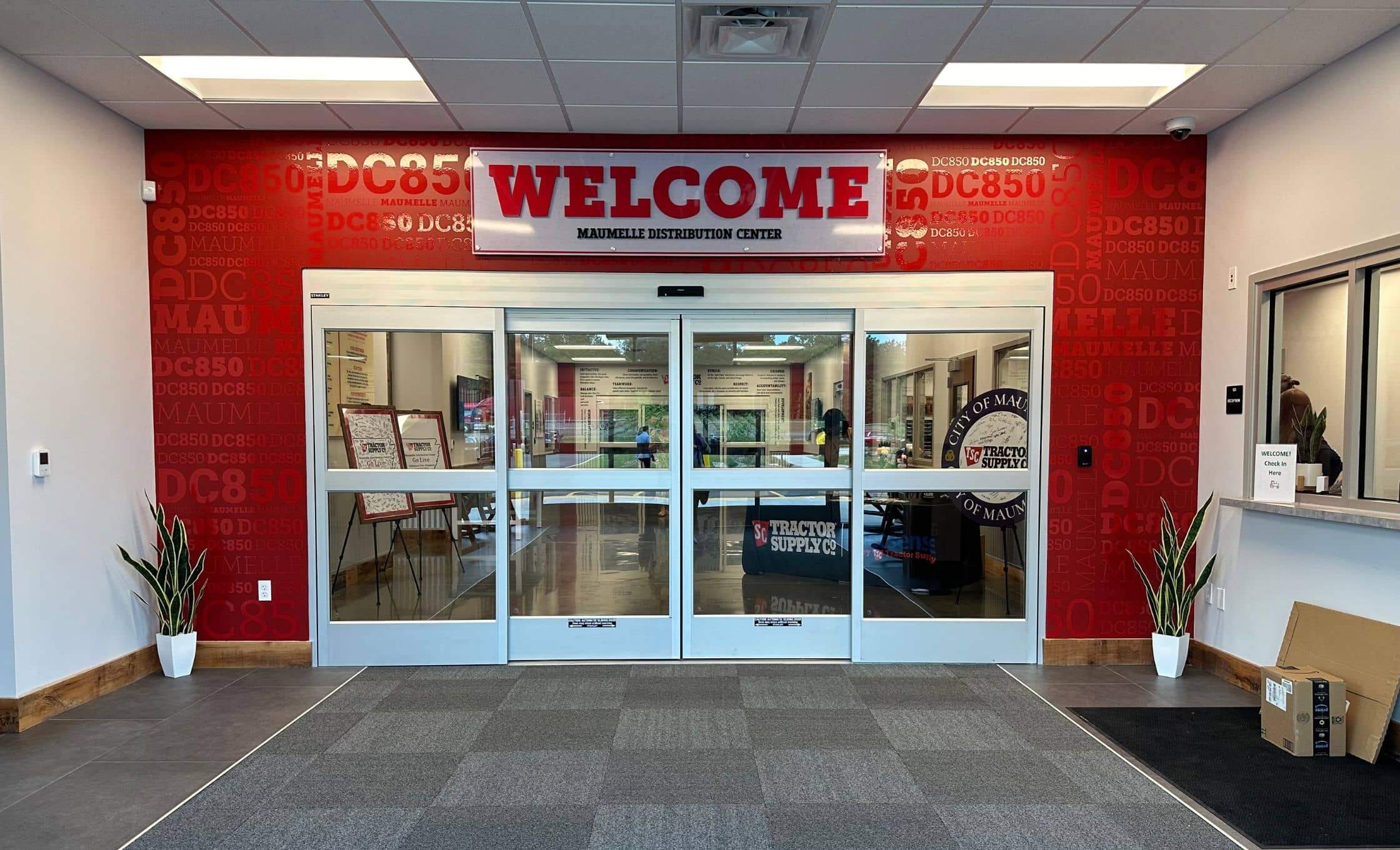 red cut and printed graphics on an interior lobby door that reads, welcome