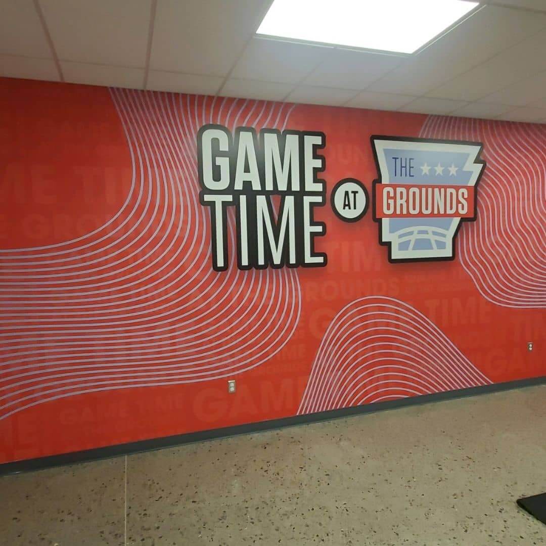 full wrap wall graphics with red pattern and silver lettering that reads, game time at the grounds 