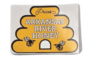 A label shaped like a beehive reads Prices Arkansas River Honey in bold letters, with two illustrated bees on either side of the hive entrance. The background is yellow and white.