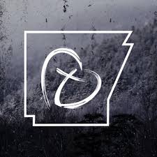 White outline of the state of Arkansas with a stylized heart and t shape inside, set against a dark, textured background.